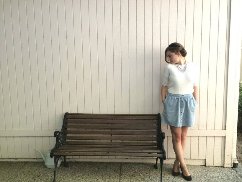 Updo hairstyle, white sweater, blue skirt, brown wedges, pink necklace