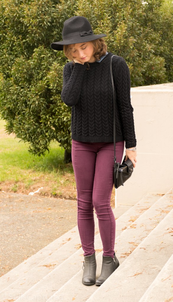 Black hat, black sweater with blue collar, purple pants, black booties, cross body purse