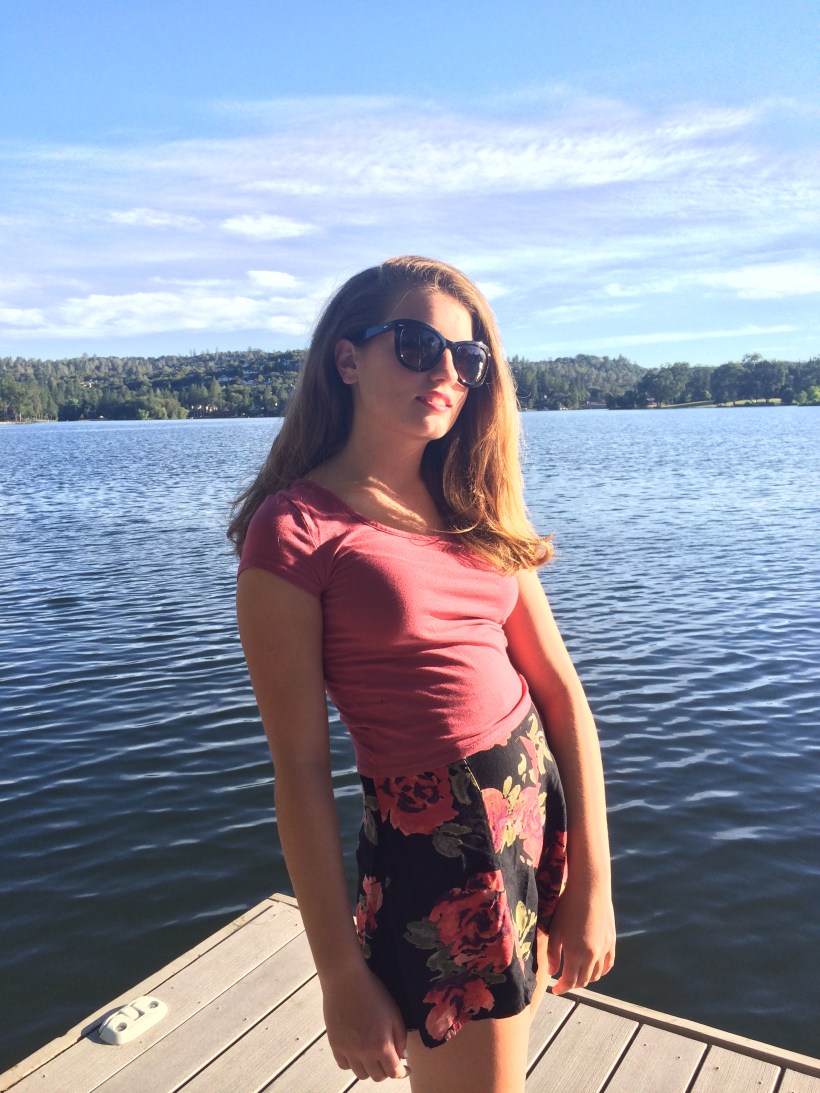 Peach crop top, floral print cloth shorts, black flats, oversized sunnies