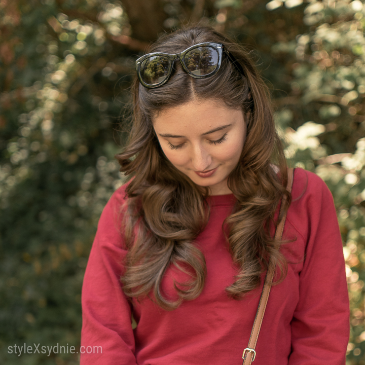 red sweatshirt, high waisted jeans, heeled slides, cross body purse